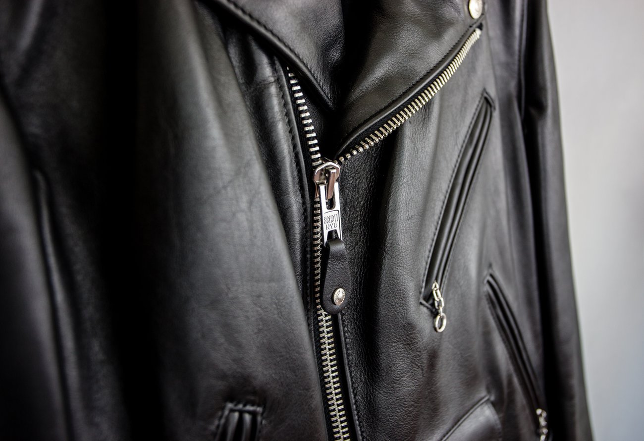 Close-up of a black leather jacket with a zipper
