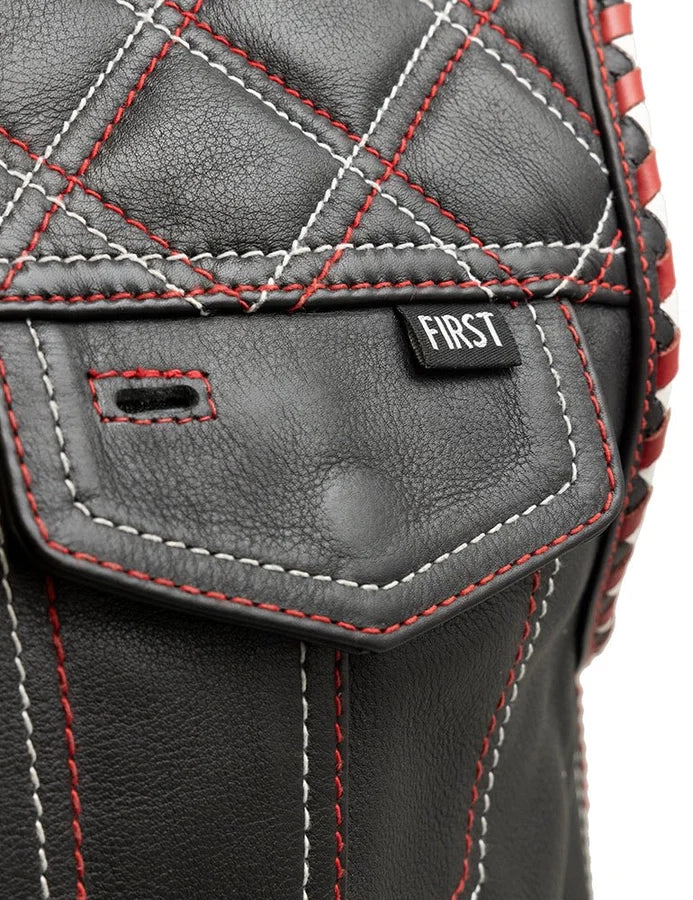 Close-up of a black leather bag with red stitching and 'FIRST' label.