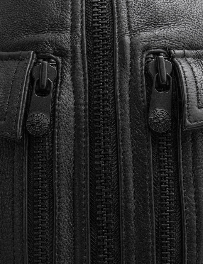 Close-up of a black leather bag with zippers