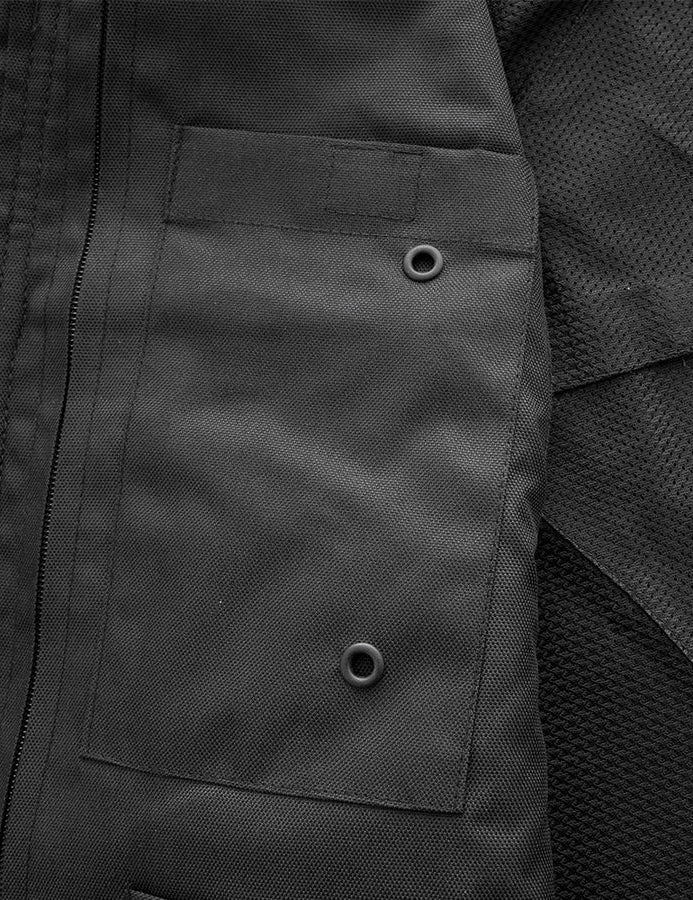Close-up of a dark gray jacket with buttoned pocket and mesh material.