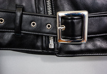 Close-up of a black leather belt with a silver buckle on a gray background