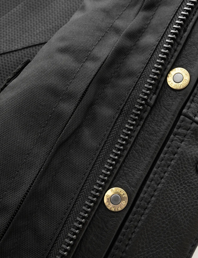 Close-up of a black jacket with gold zipper pulls and buttons.