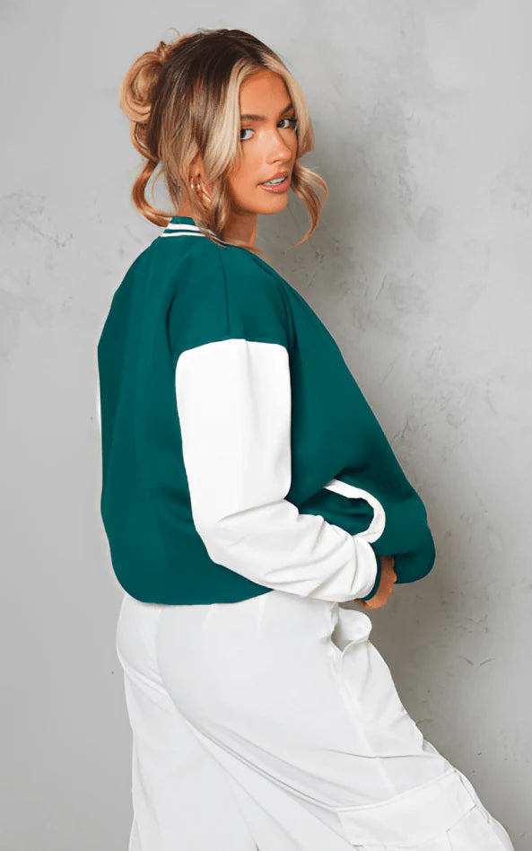 Woman wearing a green and white jacket against a gray background